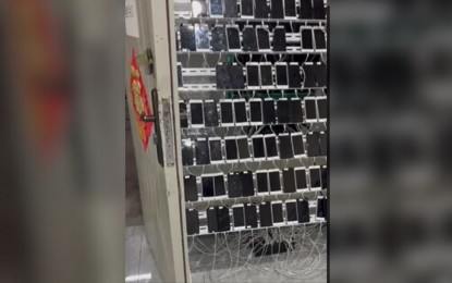 <p><strong>POGO RAID</strong>. Law enforcers find rows of mobile phones allegedly being used in scam transactions, during a raid at a POGO facility in Bamban, Tarlac on Wednesday (March 13, 2024). Authorities rescued a total of 875 Filipino and foreign workers during the operation. <em>(Photo courtesy of PAOCC)</em></p>