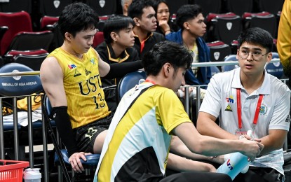 <p><strong>INJURED. </strong>University of Santo Tomas player Josh Ybañez (No. 13) gets medical treatment after hurting his left ankle during the match against University of the Philippines in the UAAP Season 86 men’s volleyball tournament at the SM Mall of Asia Arena in Pasay City on Wednesday (March 13, 2024). The Golden Spikers won, 25-23, 25-14, 25-16. <em>(UAAP photo) </em></p>