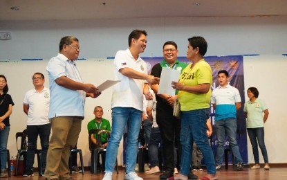 <p><strong>BIRTH CERTIFICATE FOR FREE</strong>. Bacolod City Mayor Alfredo Abelardo Benitez (2nd from left) leads the distribution of security paper copies of their certificate of live birth to residents without birth records in rites held at the Bacolod City College Activity Center on Wednesday (March 13, 2024). Assisting him are city civil registrar Hermilo Paoyon (left) and Philippine Statistics Authority-Negros Occidental chief statistical specialist John Campomanes. <em>(Photo courtesy of Bacolod City PIO)</em></p>