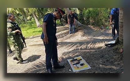<p><strong>LAW ENFORCEMENT OPERATION.</strong> A police officer inspects the firearms and hand grenade found near a suspected drug den in Barangay Semba, Datu Odin Sinsuat, Maguindanao del Norte, where gunmen traded shots with lawmen during the serving of a warrant of arrest against a wanted person on Thursday (March 21, 2024).  The shoot-out left one suspect dead and another injured. <em>(Photo from Datu Odin Sinsuat MPS)</em></p>