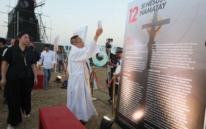 <p><strong>FAVORABLE WEATHER.</strong> A priest blesses the Life of Christ display at the TLC Park in Barangay Lower Bicutan, Taguig City on Holy Monday (March 25, 2024), which features 14 panels that represent the 14 Stations of the Cross, with Bible verses and reflection statements. The weather bureau on Tuesday (March 26) said it does not expect any tropical cyclone to affect the country during the Holy Week.<em> (PNA photo by Avito Dalan)</em></p>