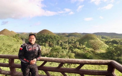 <p><strong>MOTORCYCLE TOURISM.</strong> Senator JV Ejercito poses at a viewing deck of the Chocolate Hills in Carmen, Bohol during the Bohol Loop 2024 on Saturday (March 23, 2024). Ejercito said the event was organized to showcase the beauty of Bohol through “moto-tourism.” <em>(Photo courtesy of JV Ejercito Facebook)</em></p>