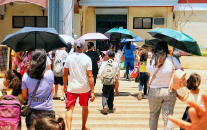 <p>SUN SHIELD. Pedestrians in Davao City use umbrellas to shield themselves from the sun's rays in this March 20, 2024 photo. In Bulacan province, Governor Daniel R. Fernando on Wednesday (April 3) reminded his constituents to protect themselves from extreme heat to avoid health emergencies. <em>(PNA photo by Robinson Niñal Jr.)</em></p>