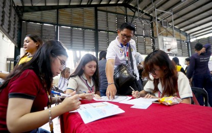 <p><strong>NEW VOTERS. </strong>A Commission on Elections staff member assists students as they register for the first time during the Voter Education and Registration Fair at the University of Santo Tomas in Manila on March 14, 2024. The poll body is implementing the Register Anywhere Program nationwide to make signing up easier and accessible.<em> (PNA photo by Yancy Lim) </em></p>