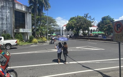 <p><strong>EXTREME HEAT.</strong> Two women use an umbrella while crossing the road to protect themselves from the sun's extreme heat in Legazpi City, Albay on Tuesday (April 2, 2024). At least four local government units in the province issued advisories directing public and private schools in their towns to implement adjusted face-to-face class schedules and adopt modular learning to the afternoon classes due to the extreme heat. <em>(Photo by Connie Calipay)</em></p>