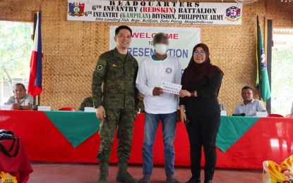 <p><strong>FINANCIAL AID.</strong> Sittie Janine Gamao (right), peace education division chief of the Ministry of Public Order and Safety (MPOS-BARMM), and Lt. Colonel Michael Glenn Manansala, the Army's 6th Infantry Battalion commander, hand over on Monday (April 1, 2024) the financial aid to one of the 20 former extremists who earlier surrendered to the military. The MPOS will also train the former insurgents to become peace advocates in their communities. <em>(Photo courtesy of MPOS -BARMM)</em></p>