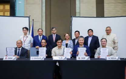 <p><strong>SOUND FINANCIAL MANAGEMENT.</strong> DILG Secretary Benjamin Abalos Jr. (seated, center) and representatives of government fiscal oversight agencies show a copy of Joint Memorandum Circular 1 s. 2024 on Public Financial Management (PFM) signed in Quezon City on Wednesday (April 3, 2024). The DILG on Friday (April 5, 2024) said this aims to strengthen the adoption of a more evidence-based approach to service delivery of LGUs to ensure that local programs and projects to be budgeted and implemented are truly responsive to the existing situation and needs of local communities. <em>(Photo courtesy of the DILG)</em></p>