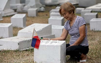 <div class="photo-area">
<div class="caption my-4">
<p><strong>HER HERO. </strong>Marilyn de Guzman, 66, offers prayers, lights candles, and leaves a Philippine flag at the tomb of her grandfather, whom she said fought during World War II, at Manila North Cemetery on Monday (April 8, 2024). On Tuesday (April 9), the country will celebrate Araw ng Kagitingan (Day of Valor) in honor of the soldiers who stood up against the Japanese occupation between 1942 and 1945. <em>(PNA photo by Yancy Lim) </em></p>
</div>
</div>