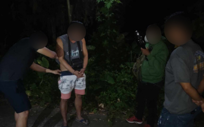 <p><strong>COLLARED</strong>. A suspect identified only as "Lyndon" is shown in this undated photo being frisked by plainclothes police operatives moments after he was arrested in a drug buy-bust operation in Nagcarlan, Laguna. The Laguna Provincial Police Office (LPPO) arrested 75 suspects during a provincewide anti-illegal drugs operation from April 1-7, 2024. <em>(Photo courtesy of LPPO)</em></p>