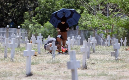 <div class="caption my-4">
<p><strong>REMEMBRANCE.</strong> Loved ones bring flowers to one of the graves at Libingan ng mga Bayani in Fort Bonifacio, Taguig City on Tuesday (April 9, 2024). They are among the proud descendants of World War II veterans whom the nation is honoring on Araw ng Kagitingan (Day of Valor). <em>(PNA photo by Yancy Lim)</em></p>
</div>