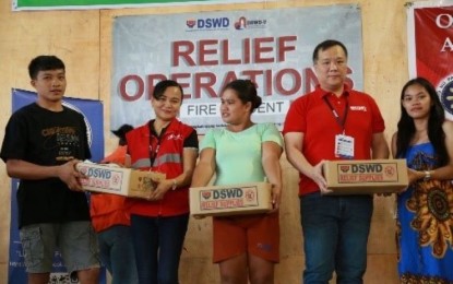 <p><strong>AID FOR FIRE VICTIMS</strong>. Department of Social Welfare and Development Assistant Regional Director for Administration Tonyson Luther Lee (second from right) hands over a family food pack to a fire victim in Mandaue City in this undated file photo. DSWD-7 (Central Visayas) regional director Shalaine Marie Lucero on Tuesday (April 9, 2024) said the agency distributed a total of PHP12.4 million worth of food, non-food, and cash assistance to 2,227 individuals who were victims of two separate fire incidents in Metro Cebu. <em>(Photo courtesy of DSWD-7)</em></p>