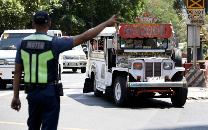 <p><strong>ENFORCEMENT.</strong> A traffic enforcer of the Philippine National Police (PNP) flagged down a public utility jeepney along Kalaw Street in Manila on April 11, 2024. Traffic enforcers of the Land Transportation Office, Metropolitan Manila Development Authority, and the PNP began their crackdown on unconsolidated public utility vehicles on Thursday (May 16, 2024), 15 days after the end of the consolidation deadline of the Public Transport Modernization Program.<em> (PNA photo by Yancy Lim)</em></p>
