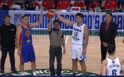 <p><strong>LET THE GAMES BEGIN.</strong> Maharlika Pilipinas Basketball League founder Manny Pacquiao (center) makes the ceremonial toss between host Pangasinan and Abra at the opening of the sixth season at Calasiao Sports Complex on Saturday (April 6, 2024). Pangasinan and Abra are among the three newcomers of the 30-team league. <em>(Screenshot from MPBL Facebook)</em></p>