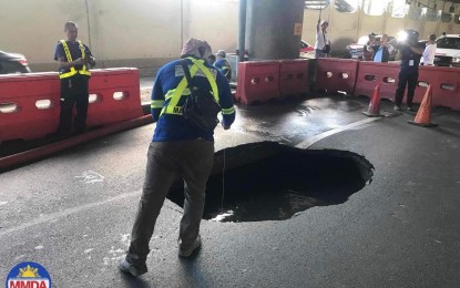 <p><strong>ROAD HAZARD.</strong> Metro Manila Development Authority personnel cordon off the sinkhole at the east-bound side of Sales Road near Villamor Air Base Gate 3 in Pasay City on Sunday (April 14, 2024). As of Monday morning (April 15), the area remains closed to motorists while it is being repaired by the Department of Public Works and Highways. <em>(Photo courtesy of MMDA)</em></p>