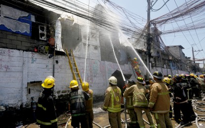<p><strong>FIRST RESPONDERS.</strong> Firefighters try to prevent the blaze from spreading in a residential area in Parola Compound, Binondo, Manila on April 12, 2024. Deputy Speaker and Cebu 5th District Rep. Vincent Franco Frasco on Tuesday (April 23) pushed for the purchase of firefighting choppers amid sudden surge of fire cases. <em>(PNA photo by Yancy Lim)</em></p>