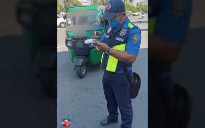 <p><strong>TICKETED.</strong> An enforcer of the Metropolitan Manila Development Authority writes a citation ticket following an apprehension of a banned e-bike on Wednesday (April 17, 2024). As of noon, the MMDA apprehended 87 vehicles and 19 were impounded as part of the ban on e-vehicles, tricycles, and other similar vehicles on national roads in the National Capital Region.<em> (Photo courtesy of MMDA)</em></p>