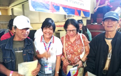 <p><strong>FIRST COPY</strong>. Alex Gabilno (leftmost) displays the birth certificate on security paper that he received from the government during the Bagong Pilipinas Serbisyo Fair on Sunday at the Benguet State University. Gabilno is among the more than 5,400 beneficiaries in the Cordillera Administrative Region for the Birth Registration Program jointly being implemented by the Philippine Statistics Authority (PSA) and the local civil registry offices in the region. <em>(PNA photo by Liza T. Agoot)</em></p>