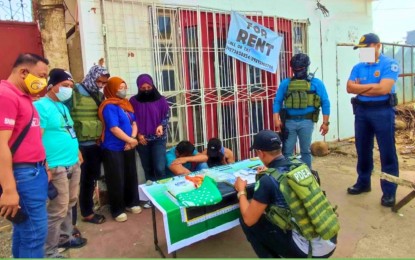 <p><strong>CAUGHT.</strong> An anti-narcotics operative lists down the illegal stuff seized from two men (covering faces) following their arrest in a drug buy-bust operation in Marawi City on Saturday (April 20, 2024). PDEA agents recovered from two suspects PHP6.8 million worth of “shabu” stuff. <em>(Photo courtesy of PDEA-BARMM)</em></p>