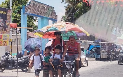 <p><strong>HEALTH HAZARD.</strong> A large umbrella shields students from the heat as they go home on a sidecar from Buenlag Central School in Calasiao, Pangasinan on April 25, 2024. Senate President Juan Miguel Zubiri on Monday (April 29) urged education officials to hasten the return to the June to March academic calendar to spare students and teachers from the ill-effects of extreme heat during the summer. <em>(PNA photo by Hilda Austria)</em></p>