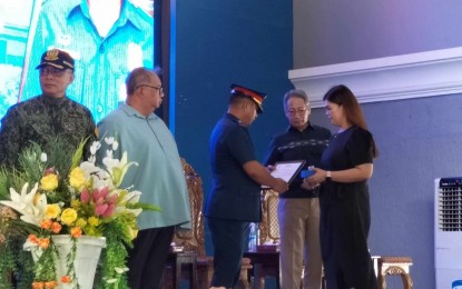 <p><strong>AWARDEE.</strong> Aiza Manero (right) on Monday (April 29, 2024) receives the Medalya ng Kadakilaan Posthumous Award for her husband, the late Corporal Reo Nograles Manero, from PRO 6 director Brig. Gen. Jack Wanky and Presidential Adviser on Military and Police Affairs Secretary Roman A. Felix (third and fourth from left). Manero died while doing a casing against a drug personality in the municipality of Pototan, Iloilo, on April 8. (<em>PNA photo by PGLena)</em></p>