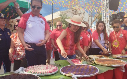 <p><strong>KANEN FESTIVAL 2024</strong>. Senator Imee Marcos (center), with Mayor Modesto Operania (left, front row), slices a native rice cake during the second Kanen Festival in Urbiztondo town, Pangasinan on Sunday (April 28,2024). The festival, which is part of the town’s annual founding anniversary celebration, aims to celebrate the bounty of agricultural products and to promote them. <em>(Photo by Hilda Austria)</em></p>