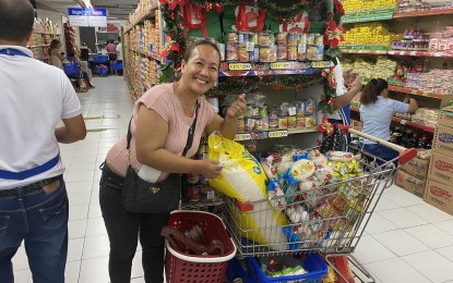 <p><strong>BASIC COMMODITIES.</strong> In this undated photo, a shopper poses with her groceries at a local department store in Negros Oriental. The Department of Trade and Industry in Negros Oriental is set to impose a price freeze on basic commodities after the province was declared a state of emergency on April 26, 2024 due to the El Niño-triggered drought.<em> (Photo courtesy of DTI-Negros Oriental Facebook Page)</em></p>