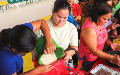 <p><strong>SUGBO MERKADONG BARATO.</strong> Members of the women's organization in Daanbantayan, Cebu pack rice to be sold at PHP20 at the town's Sugbo Merkadong Barato pop-up store, in this undated file photo. The National Food Authority promised to provide 5,000 bags of rice for Cebu's cheap market and feeding program for 878,619 kindergarten to Grade 12 learners in 1,494 public schools in the entire province of Cebu. <em>(Photo courtesy of the Municipality of Daanbantayan)</em></p>