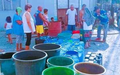 <p><strong>WATER RATIONING.</strong> Residents of Barangay Handumanan in Bacolod City line up their water containers during the distribution of water supply from the city government last week. A summary report on Saturday (May 4, 2024) showed 33,966 households in 18 affected villages availed of water rationing in April. (<em>Photo courtesy of Bacolod City-PIO)</em></p>