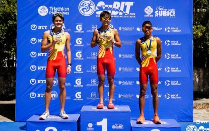 <p><strong>TOP THREE.</strong> Euan Arrow Ramos (center) rules the men's elite of the Subic Bay International Triathlon at the Subic Bay Metropolitan Authority Freeport Boardwalk on Sunday (May 5, 2024). Also on the podium are silver medalist Peter Sancho Del Rosario (left) and Diego Jose Dimayuga. <em>(Contributed photo)</em></p>