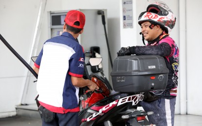 <p><strong>LOWER PUMP PRICES.</strong> A gas station attendant fills up a motorcycle fuel tank in this undated photo. Pump prices will be lower by as much as PHP1.15 per liter on July 16, driven by falling crude prices in the global market. <em>(PNA file photo)</em></p>