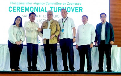 <p><strong>ADDRESSING ZOONOTIC DISEASES.</strong> Department of Health Undersecretary Glenn Mathew Baggao turns over to Department of Agriculture Undersecretary Deogracias Victor Savellano (2nd and 3rd from left, respectively) the chairmanship of the Philippine Inter-Agency Committee Zoonoses (PhilCZ) at the Bureau of Animal Industry office in Diliman, Quezon City on Monday (May 6, 2024). The DA vowed to intensify the campaign against zoonitic diseases including avian influenza, rabies, and anthrax, among others. <em>(PNA photo of Ben Briones)</em></p>