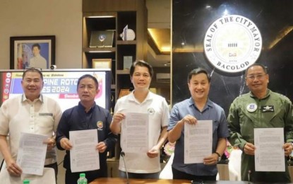 <p><strong>ROTC GAMES HOSTING.</strong> Bacolod City Mayor Alfredo Abelardo Benitez (center) with Senator Francis Tolentino (2nd from right) and Philippine Air Force Reserve Commander Maj. Gen. Elpidio Talja shows the signed memorandum of agreement for hosting the ROTC Games 2024 Visayas Regional Qualifying Leg from May 26 to June 1. They are joined by (from left) Carlos Hilado Memorial State University president Norberto Mangulabnan and CHED-Western Regional Director Raul Alvarez. (<em>Photo from Philippine ROTC Games Facebook page)</em></p>