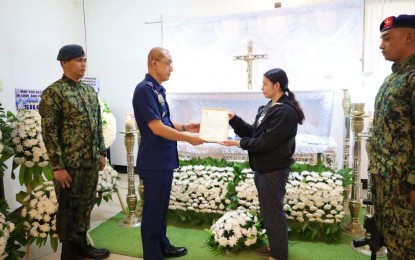<p><strong>BRAVERY.</strong> Brig. Gen. Prexy Tanggawohn, Bangsamoro police regional director, hands the "Medalya ng Kadakilaan" and financial aid to the widow of Capt. Roland Suarez Moralde on Sunday (May 5, 2024). Moralde was killed while performing his duty in Parang, Maguindanao del Norte on May 2.<em> (Photo courtesy of PRO-BAR)</em></p>