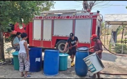 <p><strong>CONSERVE WATER.</strong> Residents of Solsona, Ilocos Norte line up drums and pails in this undated photo as Bureau of Fire Protection personnel conduct water rationing in a barangay in Ilocos Norte. The provincial government has urged the use of rainwater harvesting facilities to address water shortage. <em>(Photo courtesy of BFP Solsona)</em></p>
