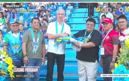 <p><strong>REGIONAL HOST.</strong> Antique provincial tourism officer Juan Carlos Perlas (fourth from left), on behalf of Governor Rhodora Cadiao, receives the Western Visayas Regional Athletic Association (WVRAA) banner from Negros Occidental Governor Eugenio Jose Lacson (third from left) during the closing ceremony of this year’s regional sports event at the Panaad Park and Stadium in Bacolod City on Tuesday (May 7, 2024). Antique will be the host of the 2025 regional sports meet. (<em>Photo screenshot from DepEd Tayo live streaming</em>)</p>
