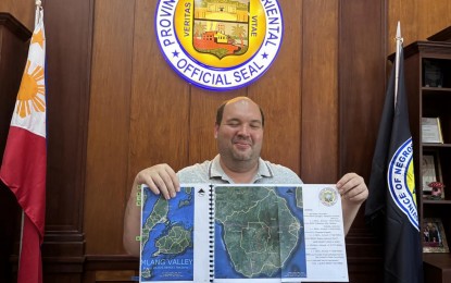 <p><strong>SCRAPPED.</strong> Negros Oriental Governor Manuel Sagarbarria shows a plan of the proposed Tamlang Valley development project which was removed from the list of priorities in Central Visayas submitted to President Ferdinand Marcos Jr.  The governor said he will relentlessly pursue the project and find ways to bring it to the attention of the President. <em>(PNA photo by Mary Judaline Partlow)</em></p>