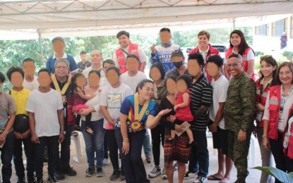 <p><strong>E-CLIP ASSISTANCE</strong>. Military and Davao de Oro provincial officials pose with the 19 former rebels after the latter received the Enhanced Comprehensive Local Integration Program (E-CLIP) assistance at the Kalayaan Village in Libasan, Nabunturan, Davao de Oro on Tuesday (May 7, 2024). Each former rebel received PHP23,000 to enable them to engage in livelihood enterprises and help them reintegrate into their communities.<em> (Photo from 1001Bde)</em></p>