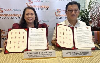 <p><strong>DEVELOPMENT PARTNERS.</strong> Mindanao Development Authority (MinDA) Secretary Maria Belen Acosta (left) and University of the Philippines President Angelo Jimenez show the memorandum of understanding for the two institutions' partnership signed on Wednesday (May 8, 2024) at the MinDA office in Davao City. The two institutions aim to collaborate on peace and development initiatives focusing on good governance, conflict mitigation, environment protection, and outreach activities.<em> (PNA photo by Che Palicte)</em></p>