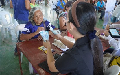 <p><strong>GOV’T AID.</strong> A rice farmer receives her PHP5,000 cash assistance under the Department of Agriculture's Rice Competitiveness Enhancement Fund – Rice Farmers Financial Assistance (RCEF-RFFA) during the distribution in Asuncion town in Davao del Norte on Wednesday (May 8, 2024). About 1,200 rice farmers received PHP5,000 each, while 41 corn farmers received PHP3,000 each for the Fuel Discount Program Caravan.<em> (Photo from DA-11)</em></p>