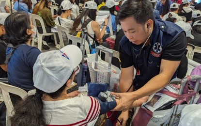 <p><strong>OUT OF DANGER.</strong> A Department of Health personnel checks on an overseas Filipino worker (OFW) upon their arrival at the NAIA Terminal 3 on Thursday (May 9, 2024). A total of 60 OFWs who availed of the government's voluntary repatriation program also received various forms of assistance. <em>(Photo courtesy of DMW)</em></p>