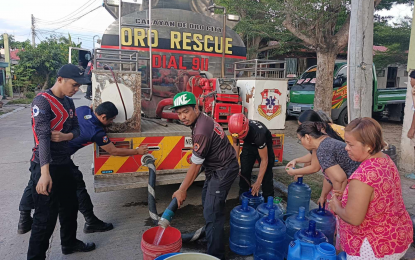 <p><strong>WATER RATION.</strong> Members of the City Disaster Risk Reduction Management Department of Cagayan de Oro on Wednesday (May 15, 2024) distribute water supply from fire trucks to affected residents of the water supply shutdown. The city government filed a temporary restraining order in court to prevent the bulk water supplier, a private firm, from cutting off its water lines. <em>(Photo courtesy of CDO CDRRMD)</em></p>