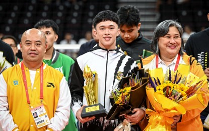 <p><strong>MOST VALUABLE PLAYER.</strong> University of Santo Tomas spiker Josh Ybañez (center) holds the UAAP Season 86 men's volleyball Most Valuable Player trophy during the awarding ceremony at the SM Mall of Asia Arena on May 15, 2024. This is his second straight MVP award. <em>(UAAP photo)</em></p>