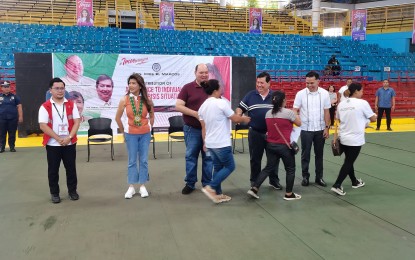 <p><strong>PAYOUT.</strong> Senator Imee Marcos (2nd from left) leads the payout of PHP16 million in government financial assistance at Macias Sports Center in Dumaguete City on Friday (May 17, 2024). The beneficiaries included 2,000 members of Parents and Teachers Associations and 2,000 students of Negros Oriental State University. <em>(PNA photo by Mary Judaline Flores Partlow)</em></p>