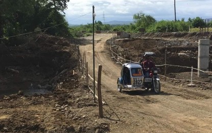 <p><strong>BETTER ROAD</strong>. Batac residents pass through the dirt road in Camandingan, Batac City, Ilocos Norte in this undated photo. A PHP20 million farm-to-market road will soon be constructed here, providing better access to the community. <em>(Photo courtesy of Batac LGU)</em></p>