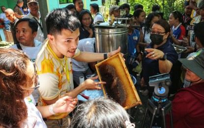 <p><strong>BEES AND HONEY.</strong> James Ryan Abonales, a senior beekeeper at Loyola Apiary Farm in Panabo City, Davao del Norte, conducts an actual honey harvesting demonstration on Monday (May 20, 2024), marked as World Bee Day. The Department of Agriculture-Davao Region encourages the youth to venture into apiculture and promote the importance of bees to food security. <em>(PNA photo by Robinson Niñal Jr.)</em></p>