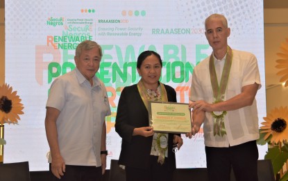 <p><strong>RENEWABLE ENERGY WEEK.</strong> Director Marissa Cerezo (center) of the Department of Energy  Renewable Energy Management Bureau receives a certificate of appreciation from Negros Occidental Governor Eugenio Jose Lacson (right) and former governor Rafael Coscolluela, the provincial consultant on energy and environment concerns. “We recognize that the province of Negros Occidental is among the first to champion RE,” she said in her keynote message during the opening program of the Provincial Renewable Energy Week held at the Ayala Malls Capitol Center in Bacolod City on Monday (May 20, 2024). <em>(Photo courtesy of PIO Negros Occidental</em>)</p>