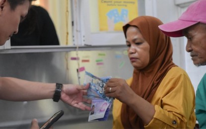<p><strong>LIVELIHOOD AID</strong>. A returning overseas Filipino worker receives her financial assistance from the Ministry of Labor and Employment in the Bangsamoro Autonomous Region in Muslim Mindanao (MOLE-BARMM) in Cotabato City on Tuesday (May 21, 2024). She and 174 others received aid from the government through the MOLE's Reintegration Program for the 'Balik Bangsamoro Hanap Trabaho.' <em>(Photo courtesy of MOLE-BARMM)</em></p>