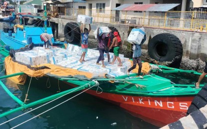 <p><strong>INTERCEPTED.</strong> Apprehended crew members of motorbanca "Vikings" unload master cases of smuggled cigarettes at the Bureau of Customs Sub-Port of General Santos City on May 22, 2024. The Philippine Navy on Tuesday (May 28, 2024) reported that units of the Naval Forces Eastern Mindanao intercepted the motorbanca carrying PHP21 million worth of smuggled cigarettes while on patrol off Balut Island, Davao Occidental province. <em>(Photo courtesy of Naval Forces Eastern Mindanao)</em></p>