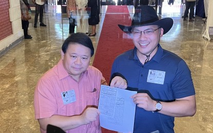 <p><strong>PETITION.</strong> Duterte Youth leader Ronald Cardema (right) and his counsel Ferdinand Topacio show a copy of the petition to deny due course they filed against the P3PWD party-list at the Comelec main office in Intramuros, Manila on Monday (June 3, 2024). Cardema said the P3PWD must not be allowed to join the 2025 polls for failing to comply with the deadline for the filing of its Manifesation of Intent to Participate.<em> (PNA photo by Ferdinand Patinio)</em></p>