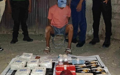 <p><strong>BIG HAUL</strong>. A suspected big-time illegal drug trader sits in front of six kilograms of suspected shabu valued at around PHP40.8 million after his arrest in Sitio Arko Ali, Barangay Labangon, Cebu City on Monday night (June 3, 2024). The suspect is considered a high-value individual in the regional drug watchlist.<em> (Contributed photo)</em></p>